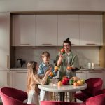 Mother with children preparing meals with fresh ingredients in a modern kitchen.